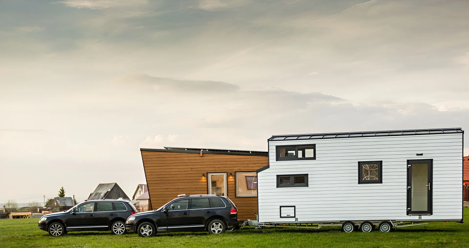 Two Cars Pulling Tiny Homes on a Grassy Field — ASAP Towing Pty Ltd In Gympie, QLD