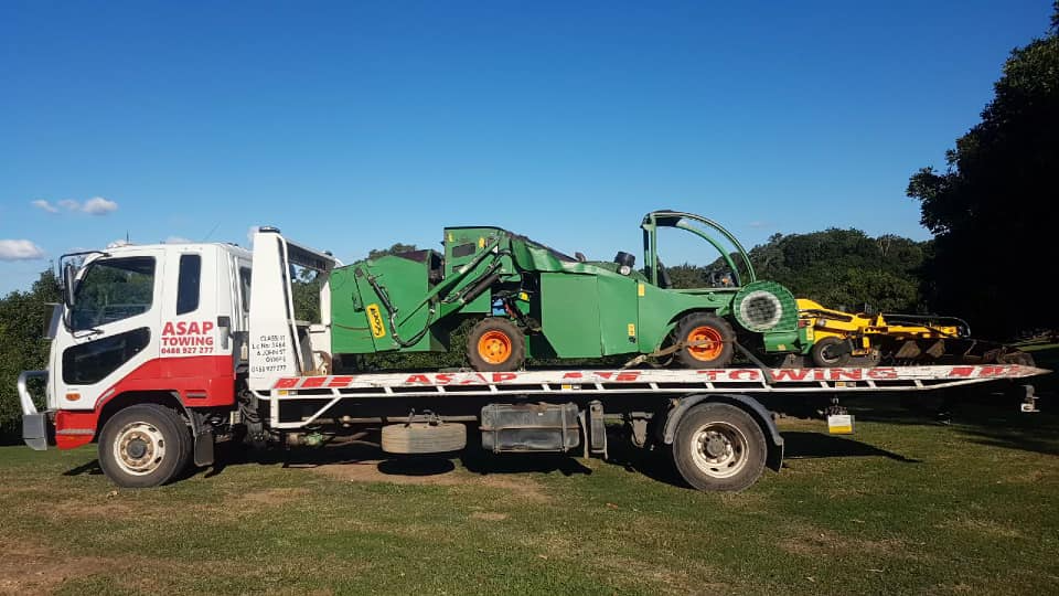 A Green Tractor is Secured on a Flatbed Tow Truck — ASAP Towing Pty Ltd In Gympie, QLD