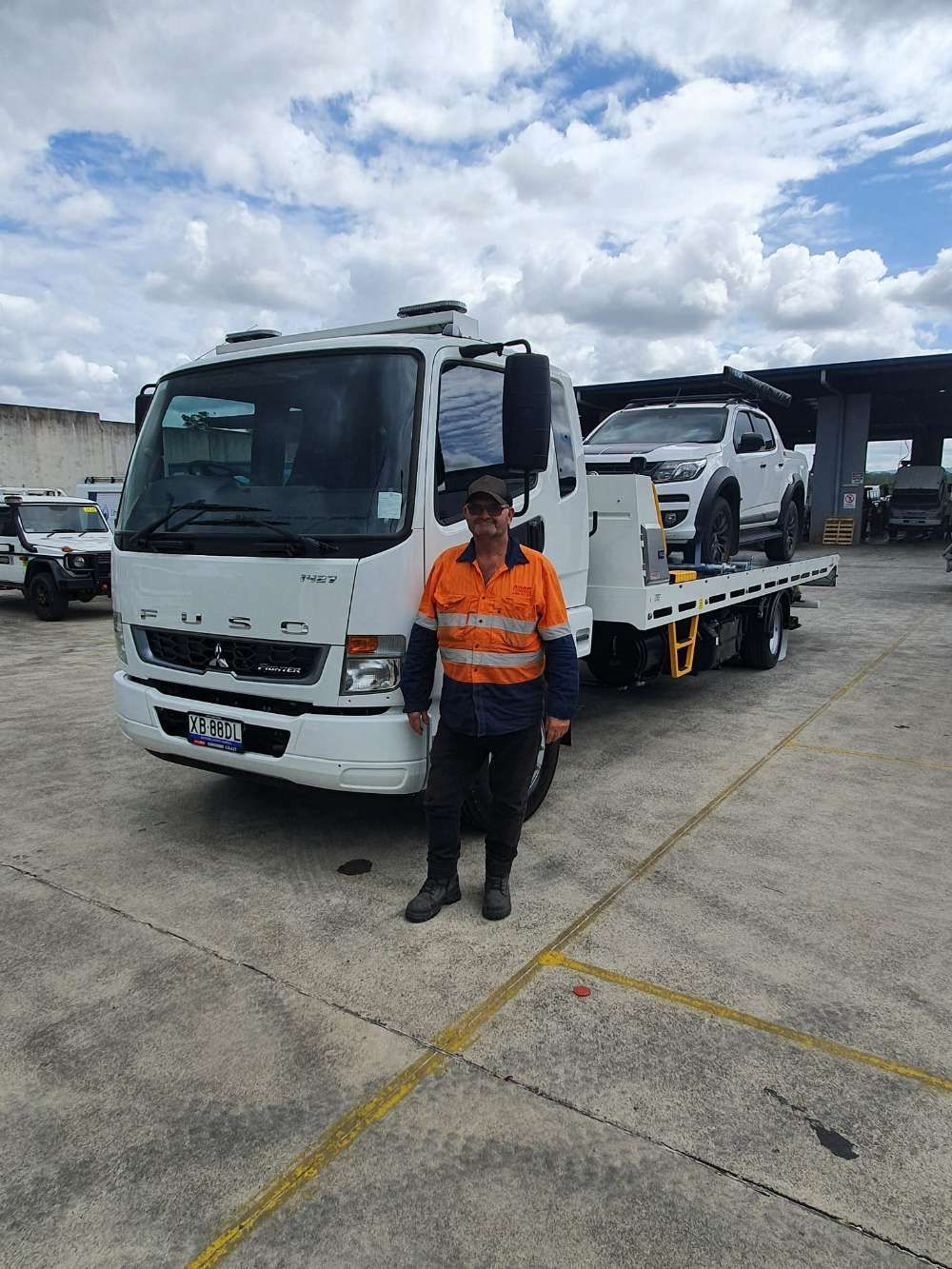 Man in Work Clothes Stands by a White Tow Truck — ASAP Towing Pty Ltd In Gympie, QLD