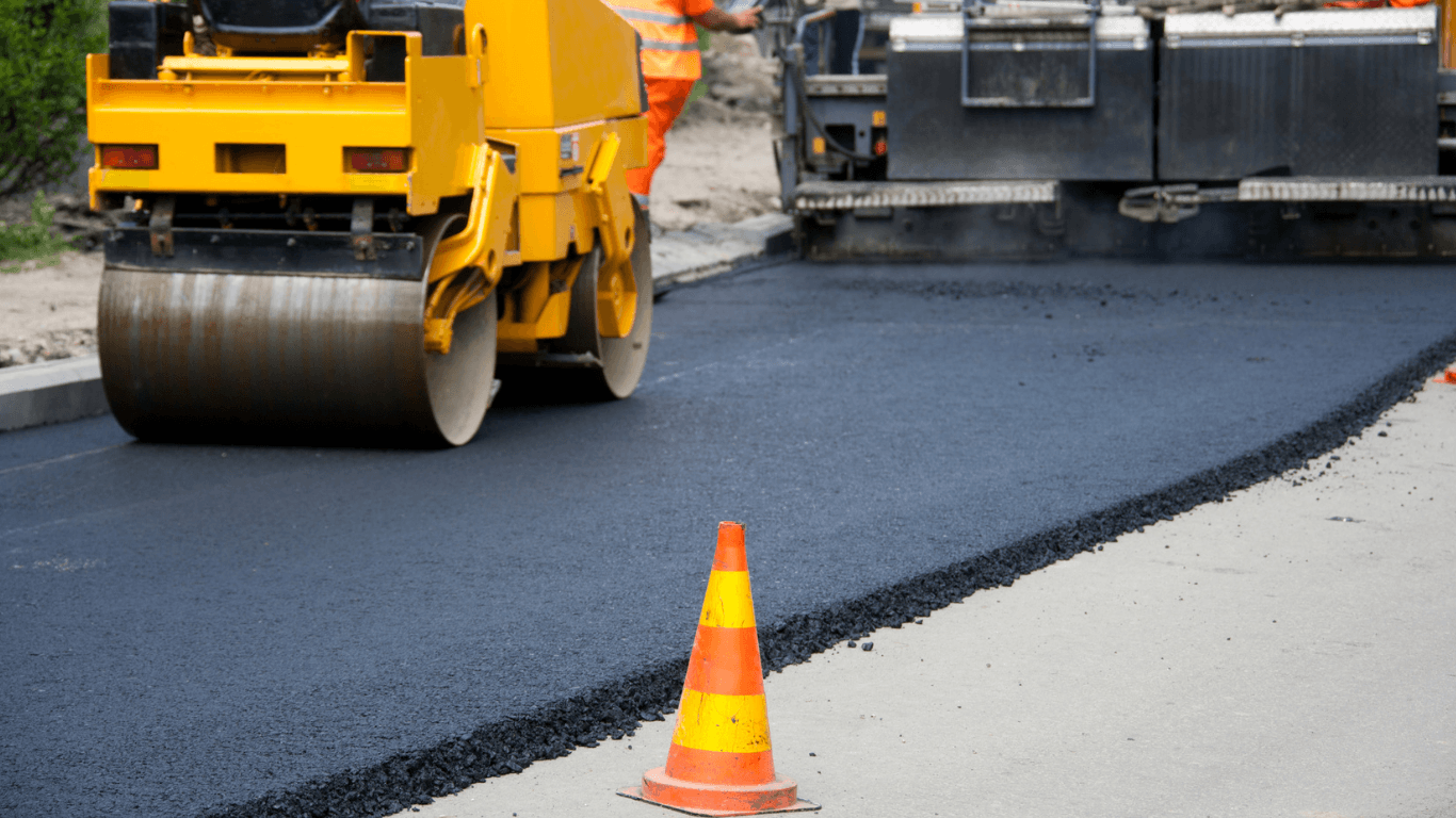 an asphalt contractor paving a parking lot