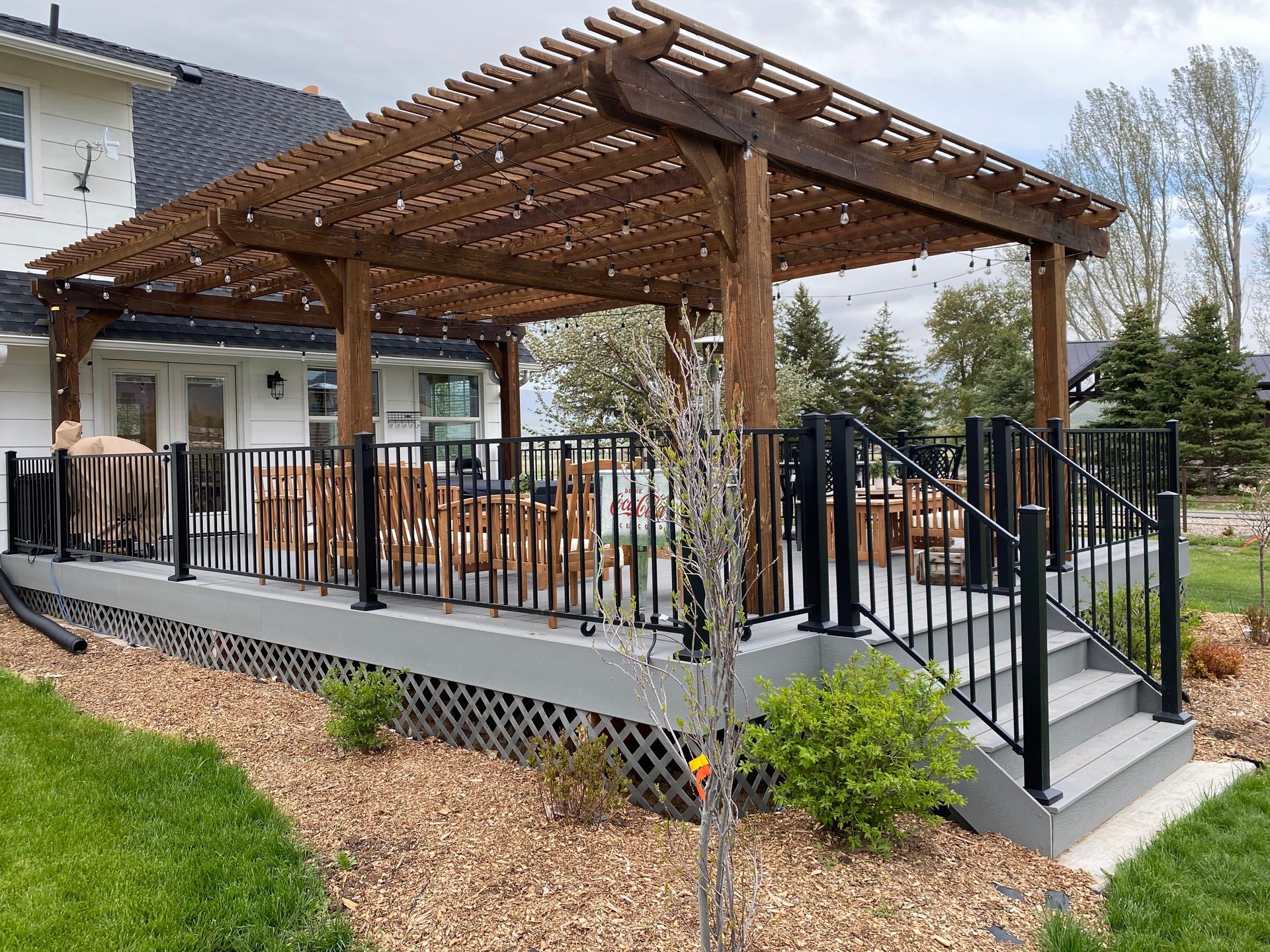 a deck with a pergola and stairs in front of a house .