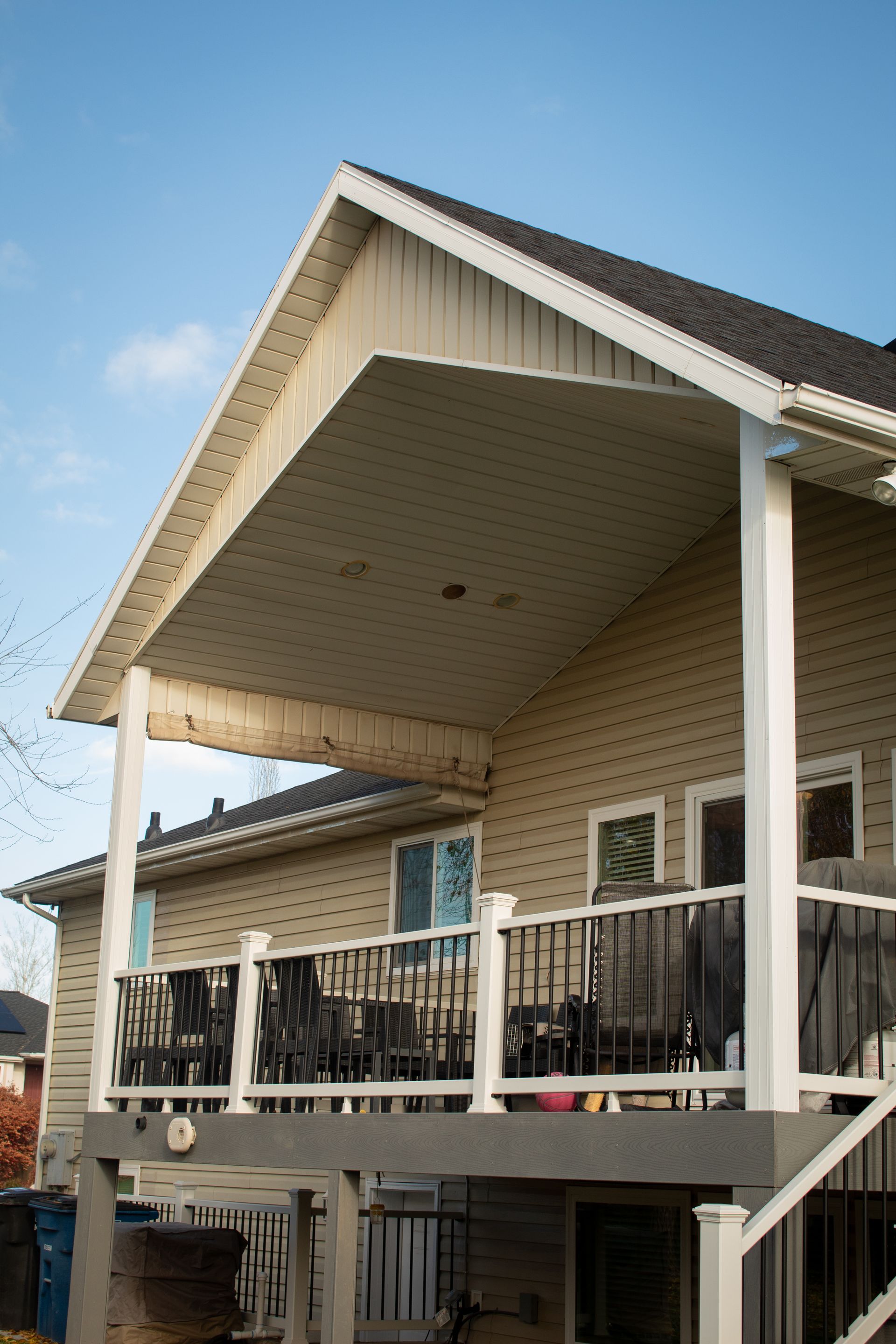 a man is standing on a ladder measuring a gutter with a tape measure .