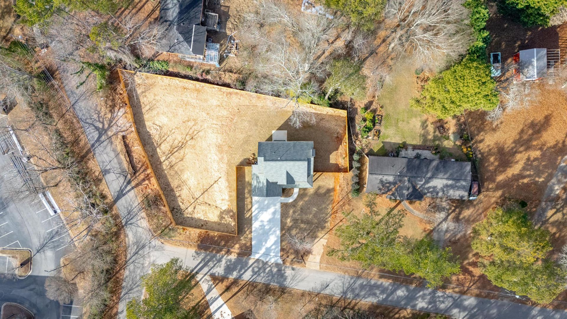 An aerial view of a house in the middle of a forest.