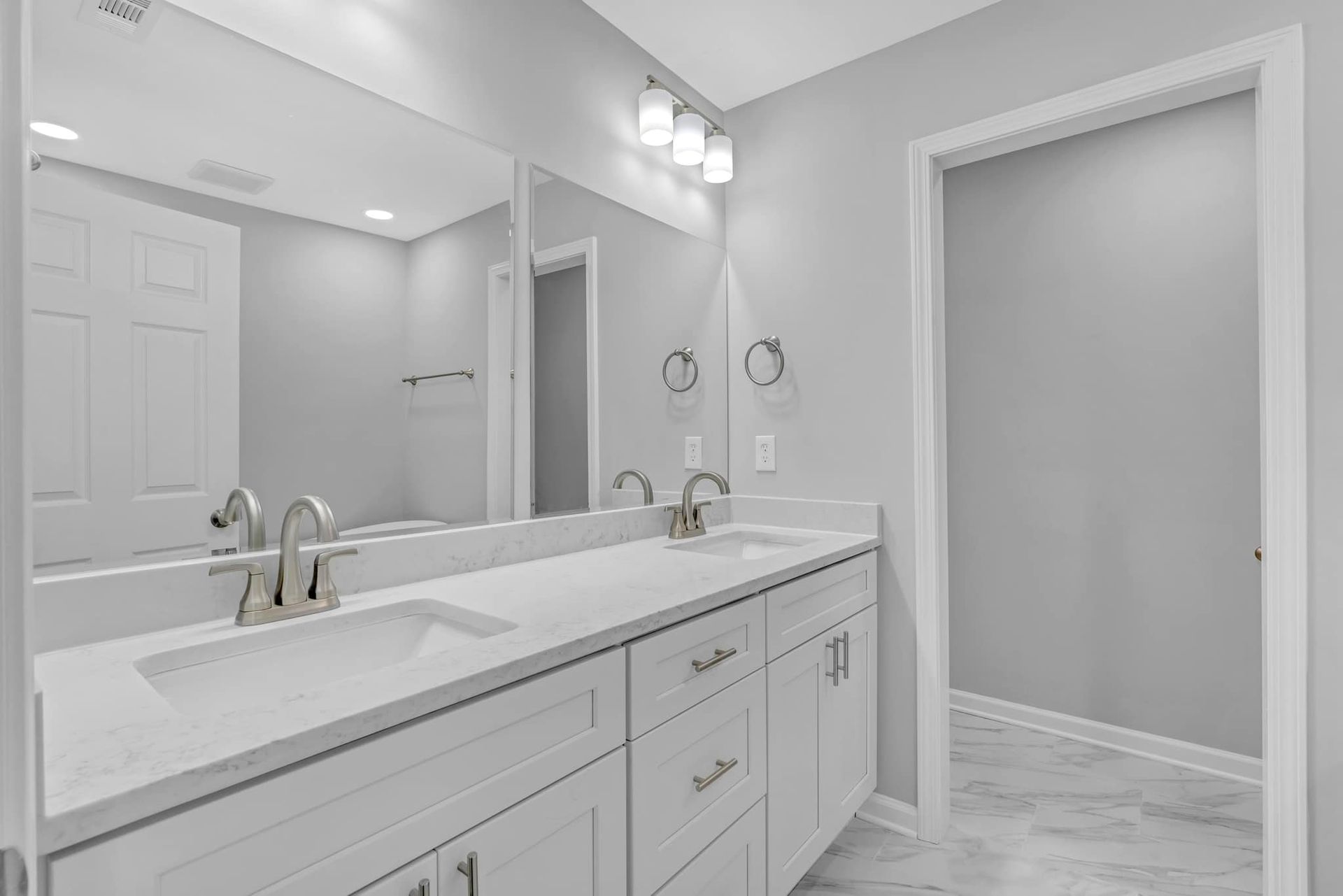 A bathroom with two sinks and a large mirror.