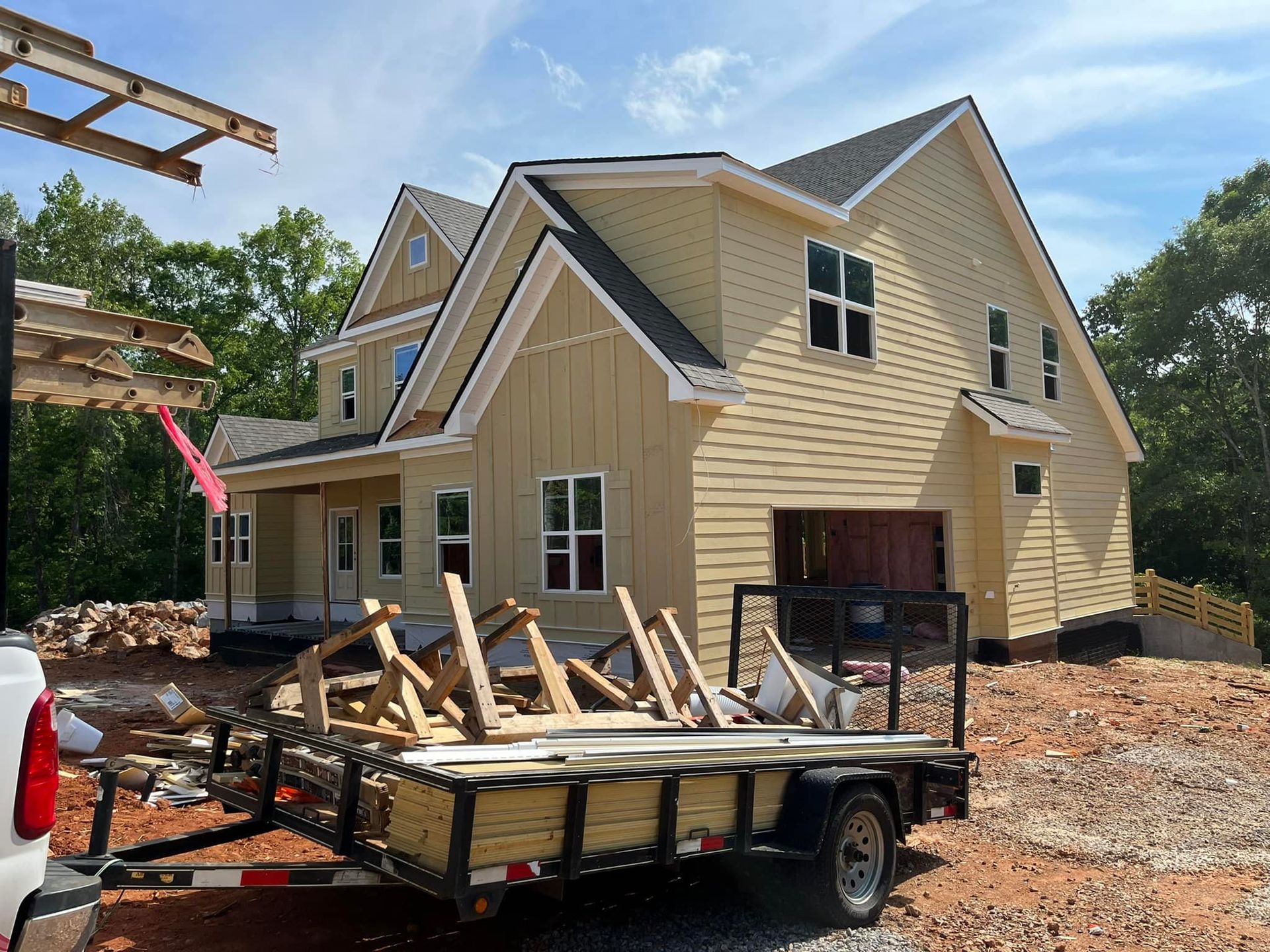A trailer is parked in front of a house under construction.