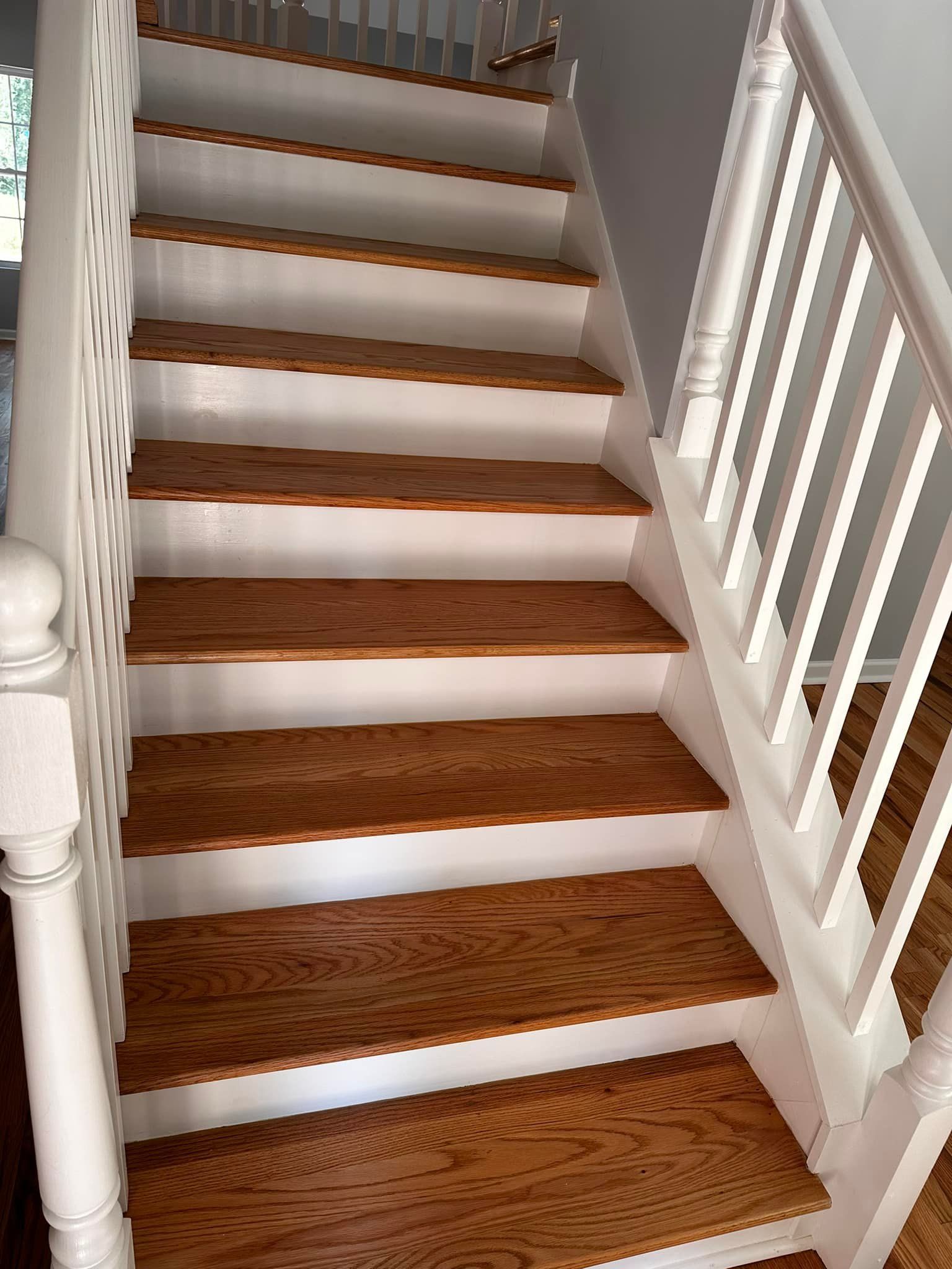 A staircase with wooden steps and a white railing.