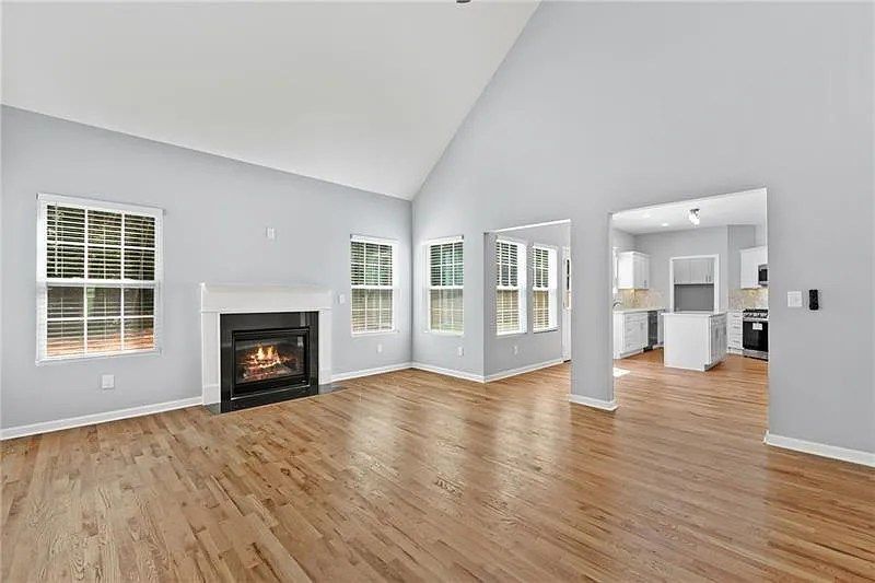 An empty living room with hardwood floors and a fireplace.