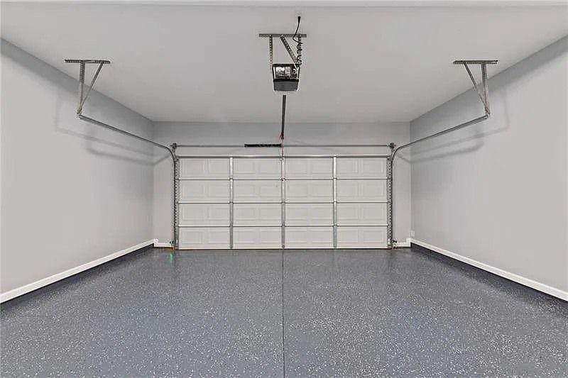 An empty garage with a garage door open and a ceiling lift.