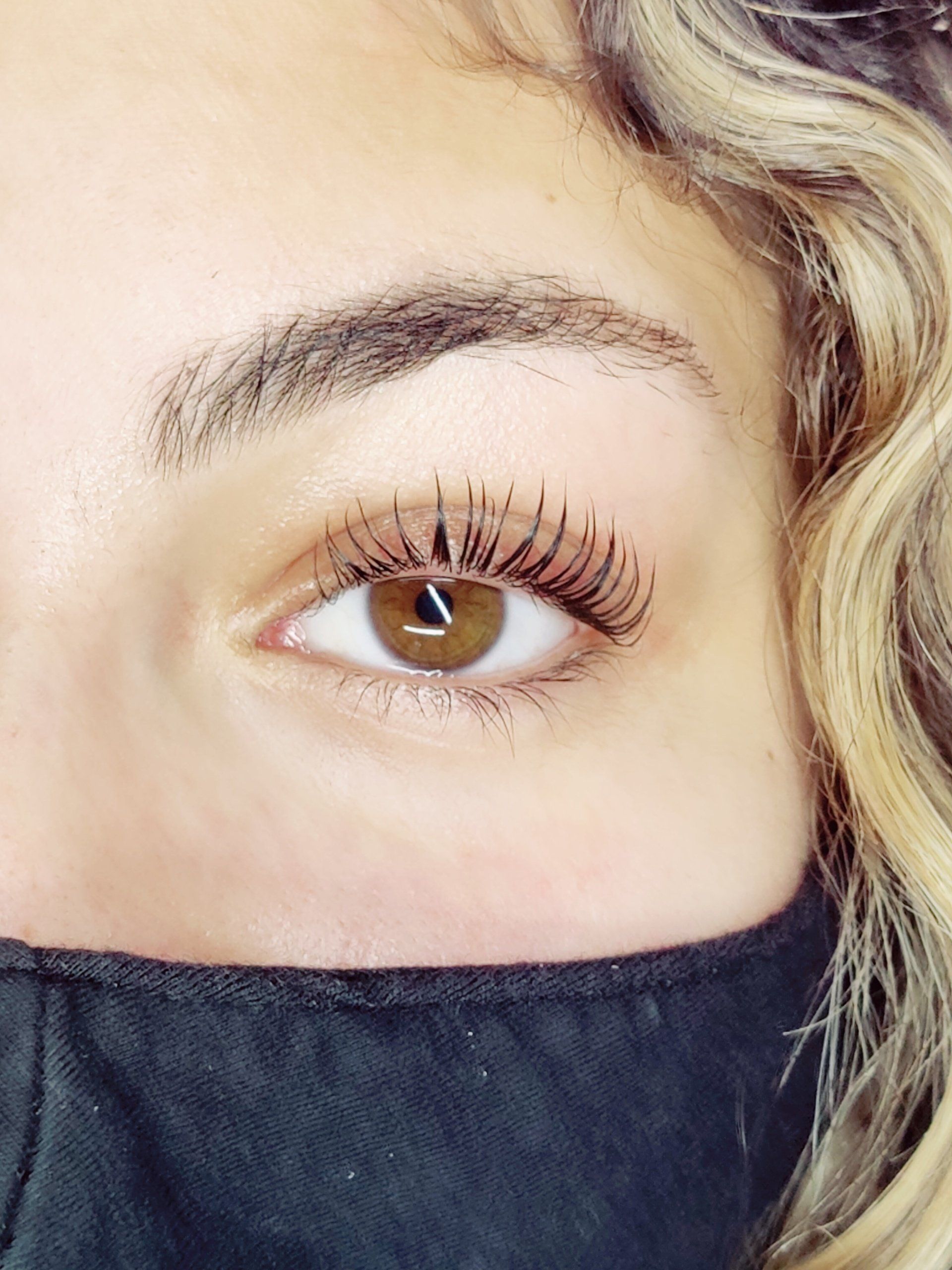 A close up of a woman 's eye wearing a black mask