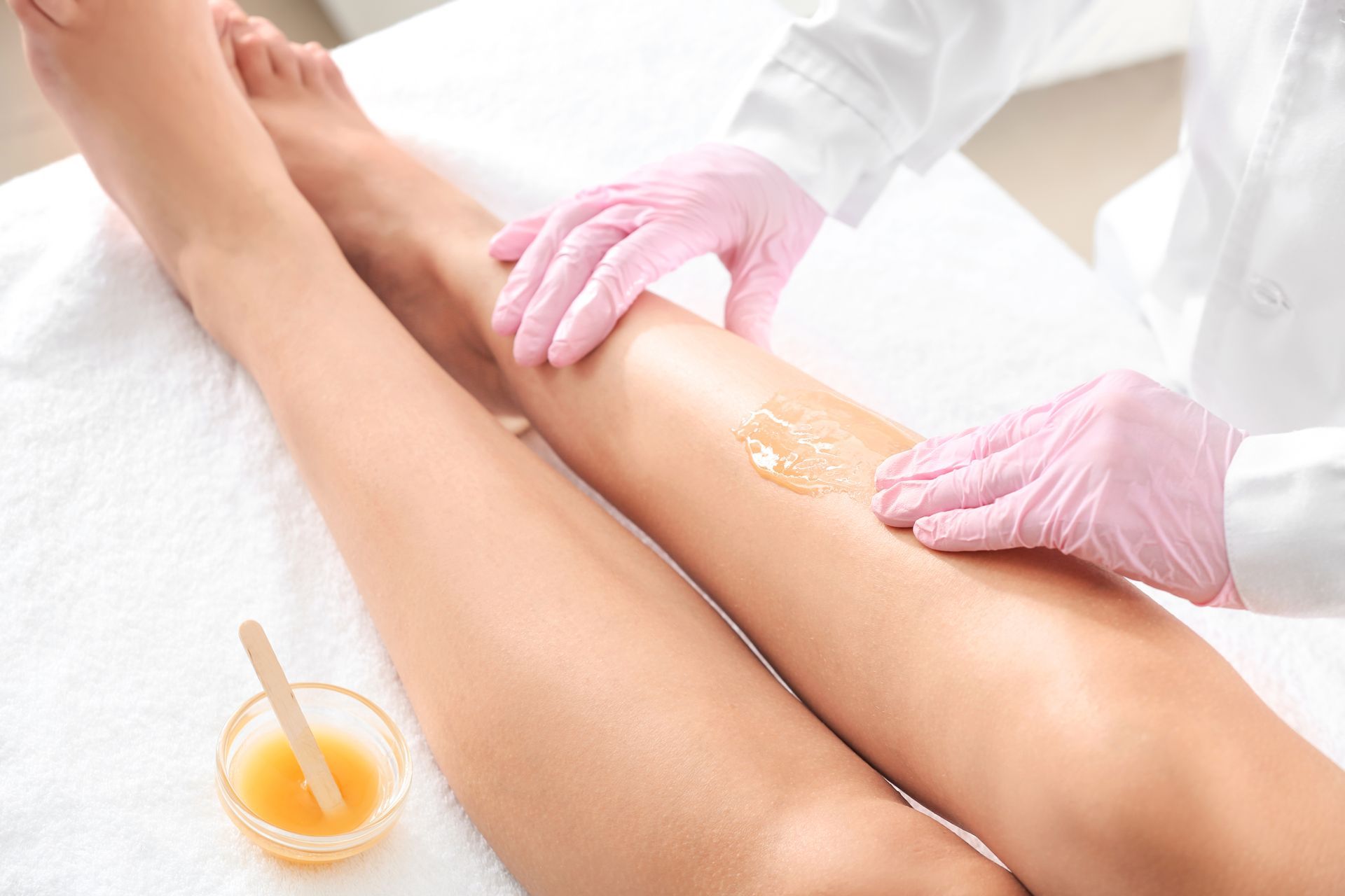 A woman is getting her legs waxed in a beauty salon.