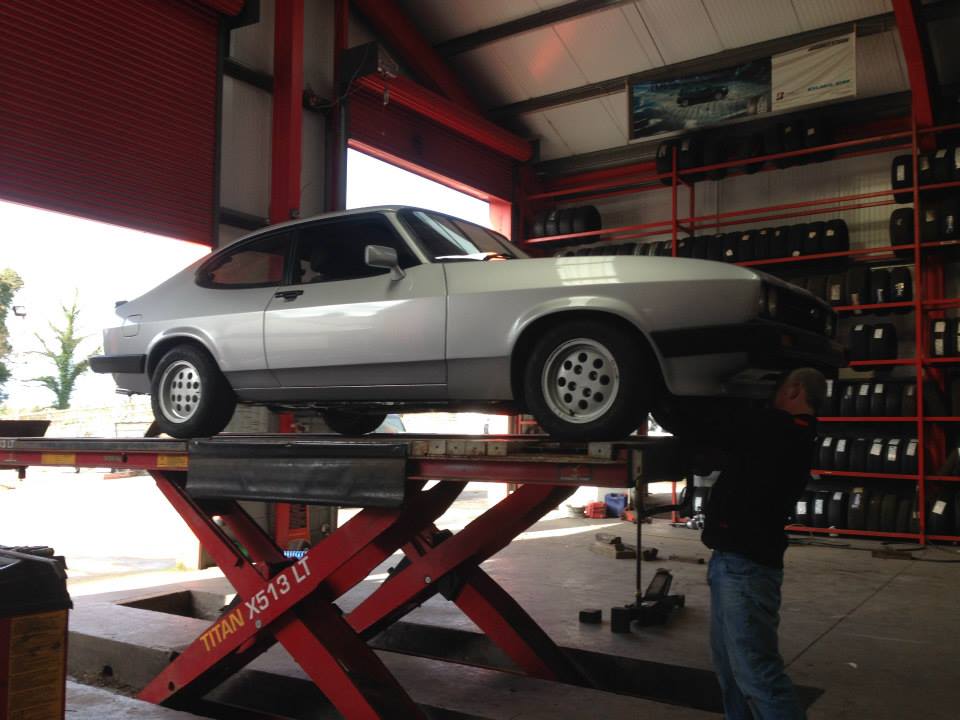 silver car up on lift