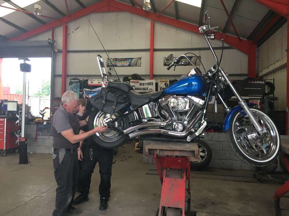 men fixing blue motorbike
