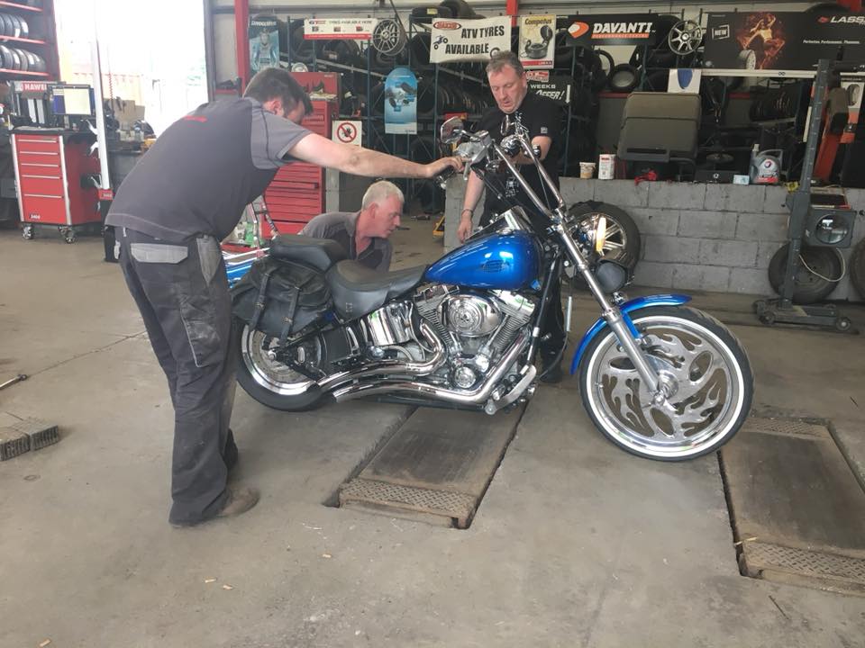 men fixing blue motorbike