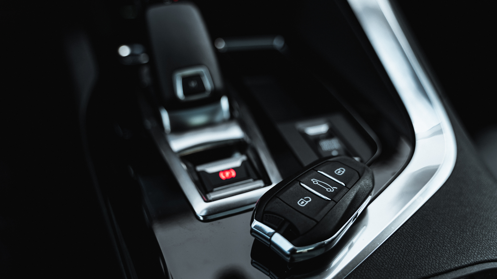 A close up of a car key in the center console of a car.