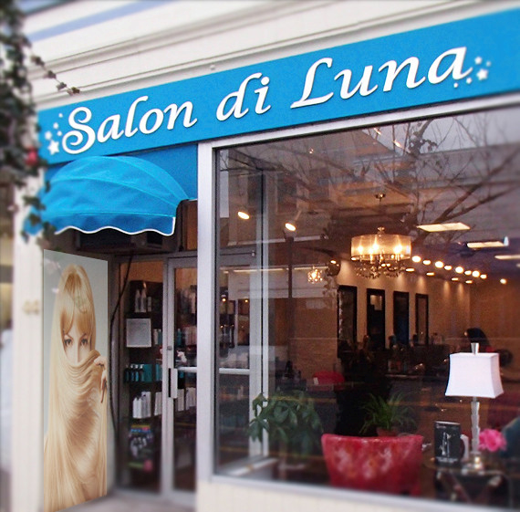 A salon with a blue awning that says salon di luna