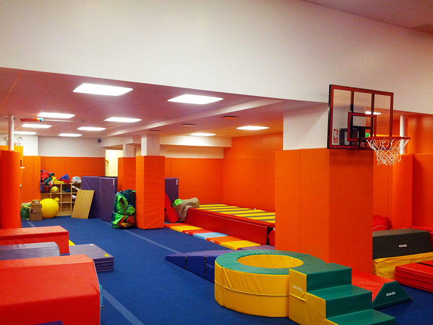 A gym with a basketball hoop on the wall