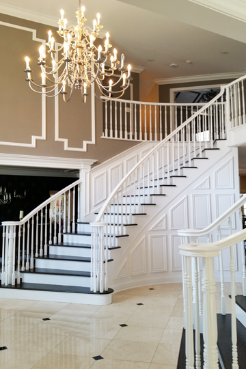 A large staircase with a chandelier hanging from the ceiling