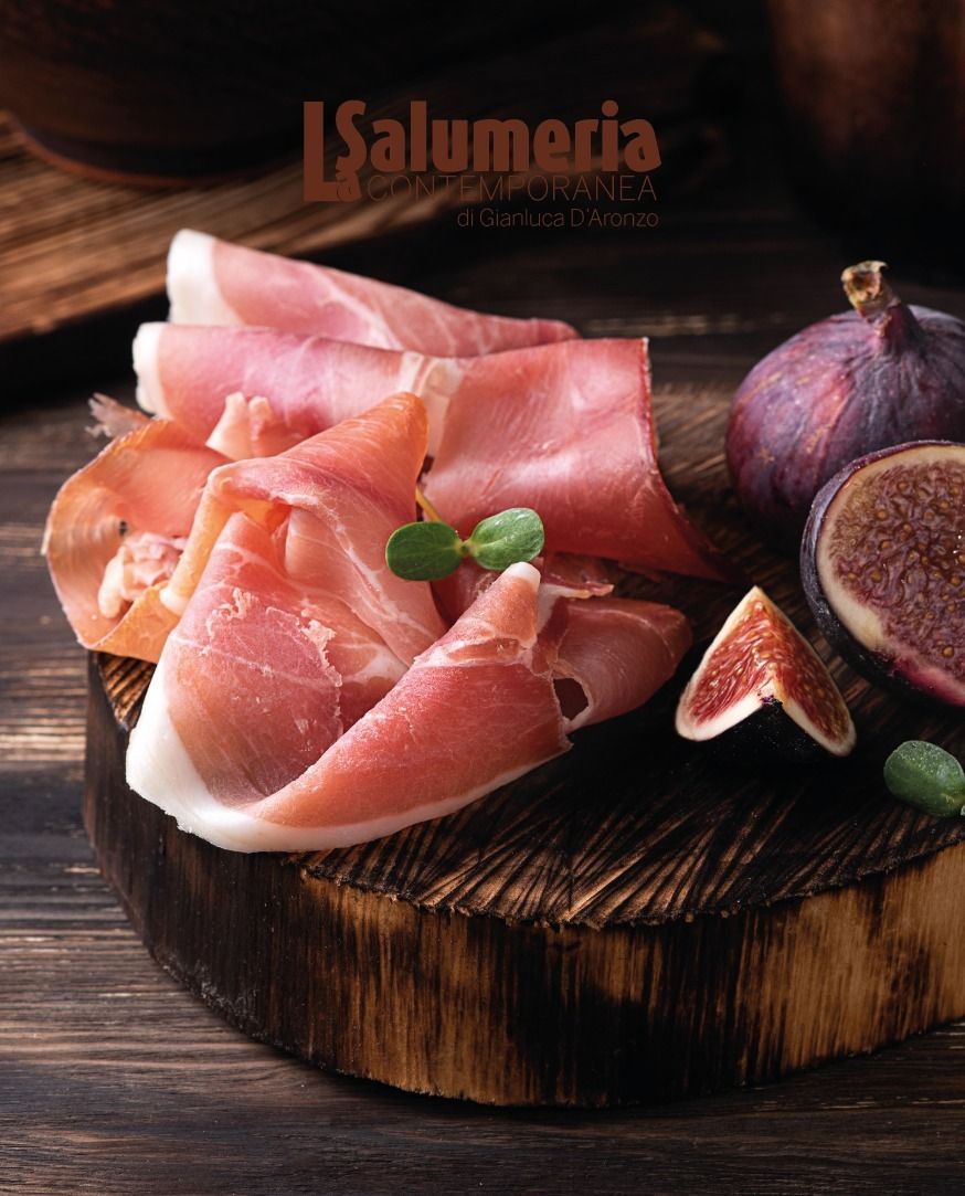 Fette di prosciutto con fichi su un tagliere di legno.