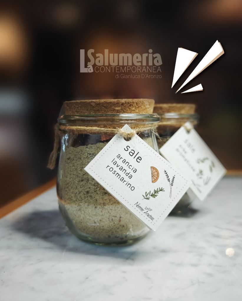 Due barattoli di vetro con coperchi di sughero, ciascuno con un'etichetta che riporta la scritta 