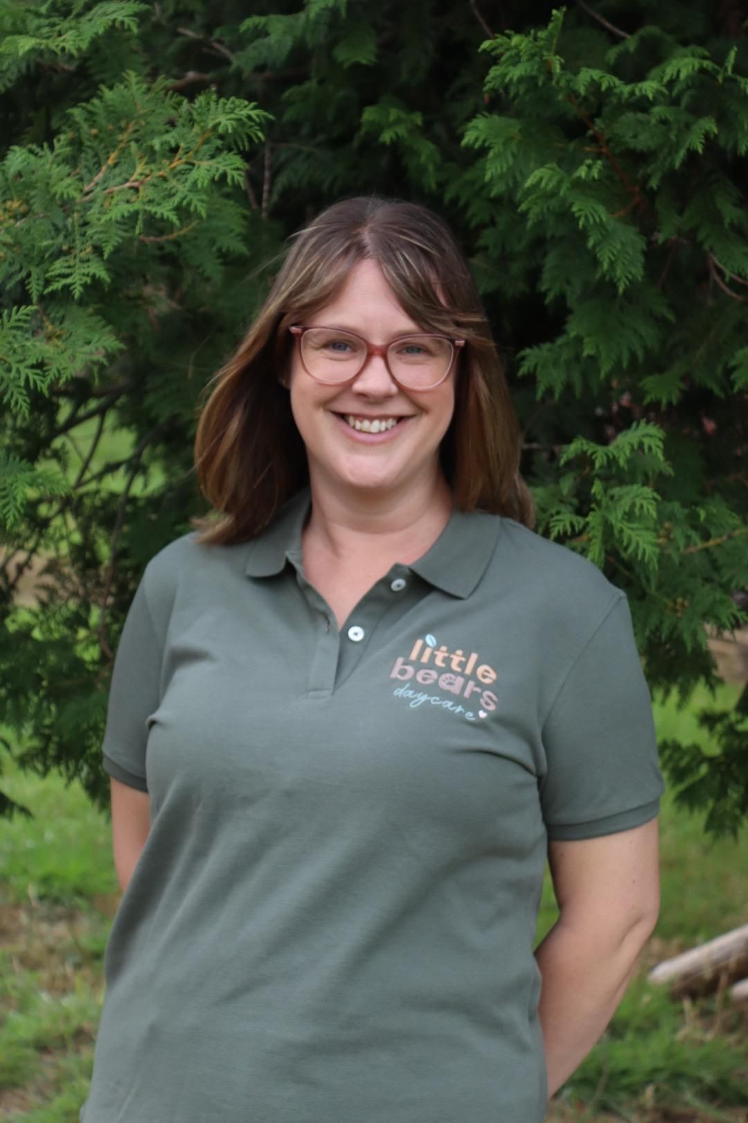 Woman wearing glasses and a green polo shirt with 