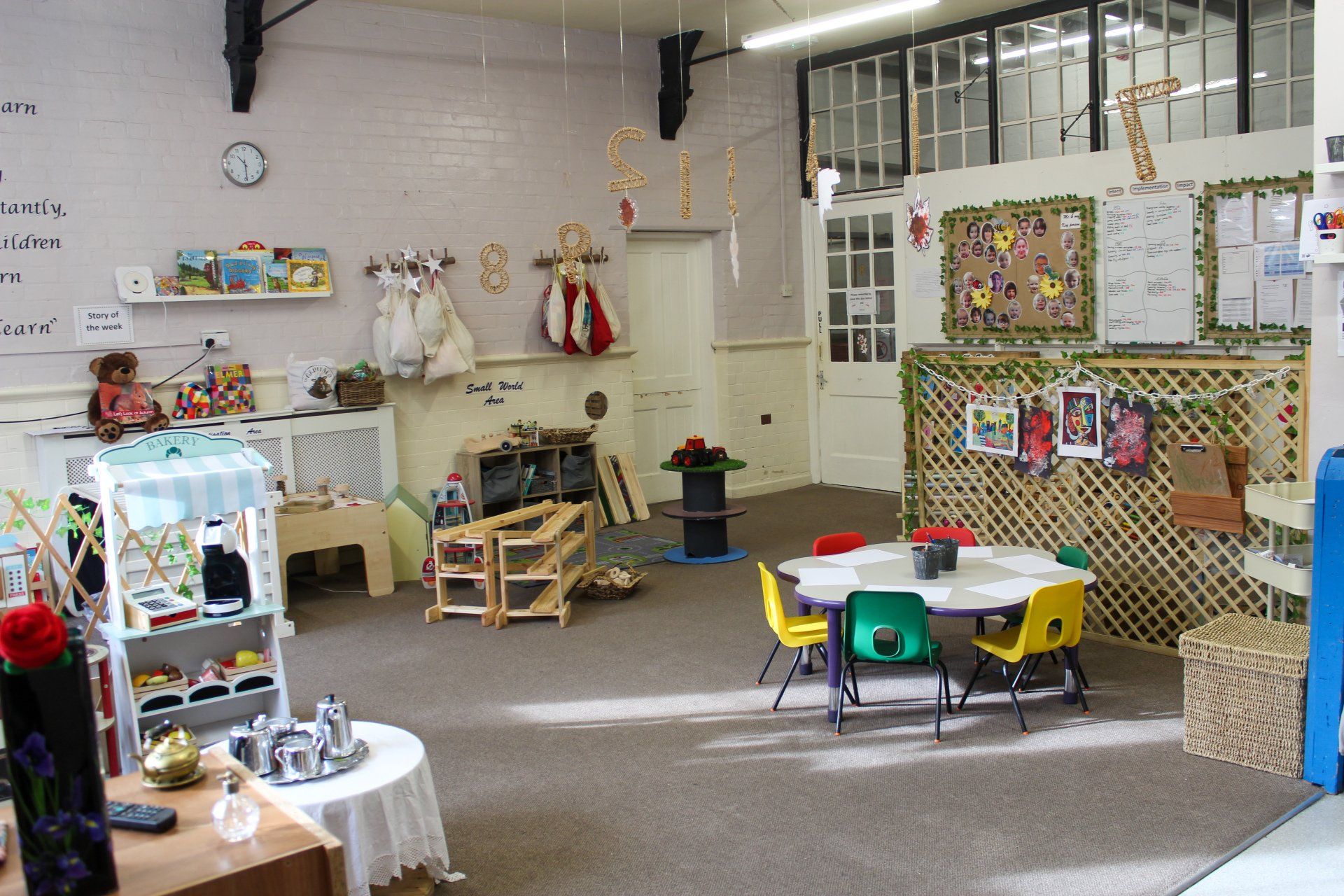 Interior of a children's play area with tables, chairs, toys, and decorations.