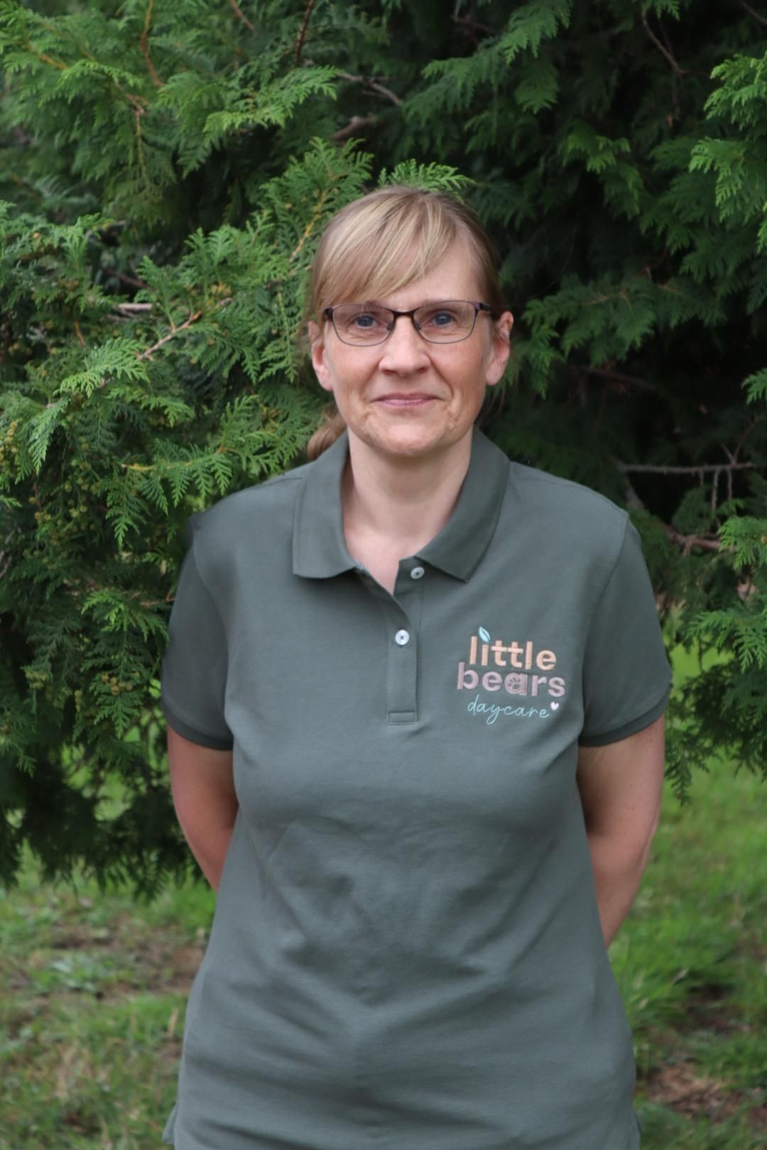 Woman wearing glasses and a green polo shirt with 