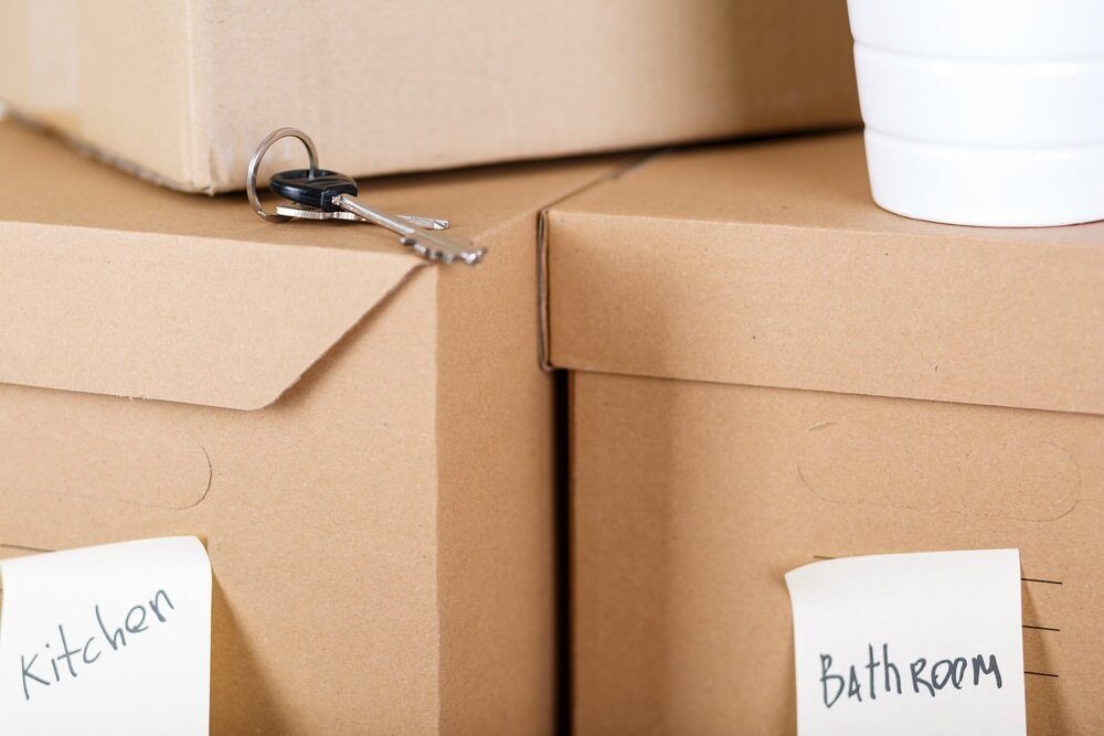A Stack of Cardboard Boxes With Labels for Kitchen and Bathroom — Johns Removals Newcastle In Gosford, NSW