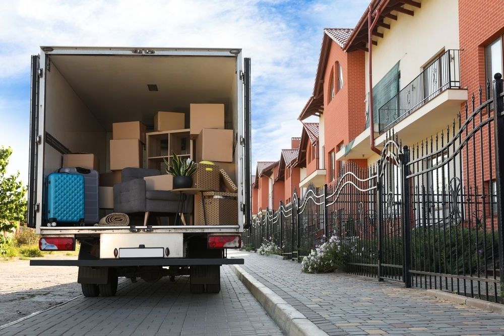 A Moving Truck Filled With Boxes is Parked on the Side of the Road — Johns Removals Newcastle In Wyong, QLD