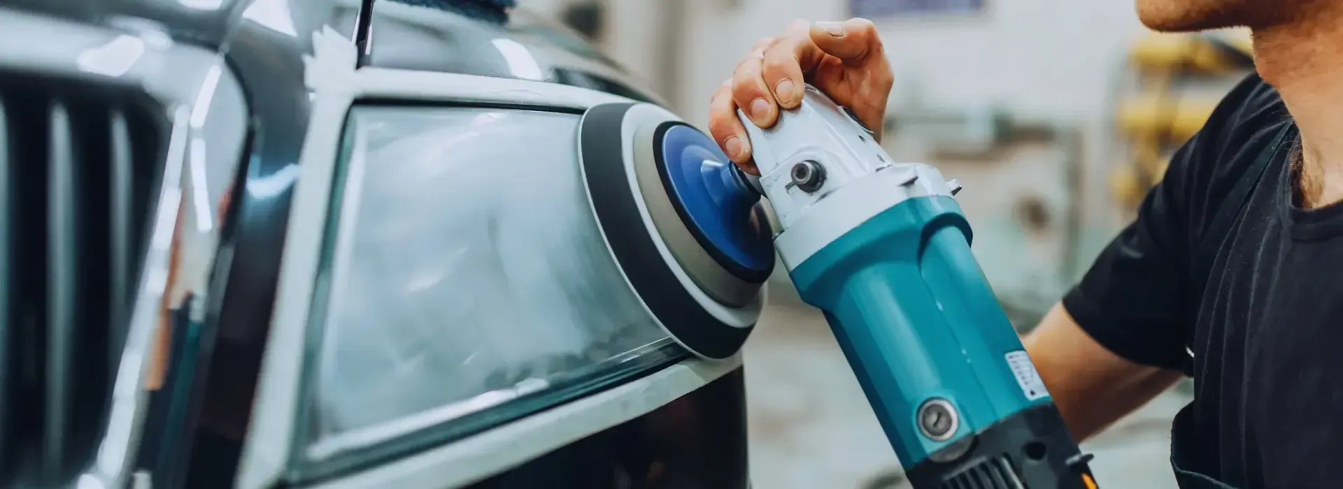 A man is polishing a car with a machine.