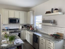 A kitchen with white cabinets and stainless steel appliances.