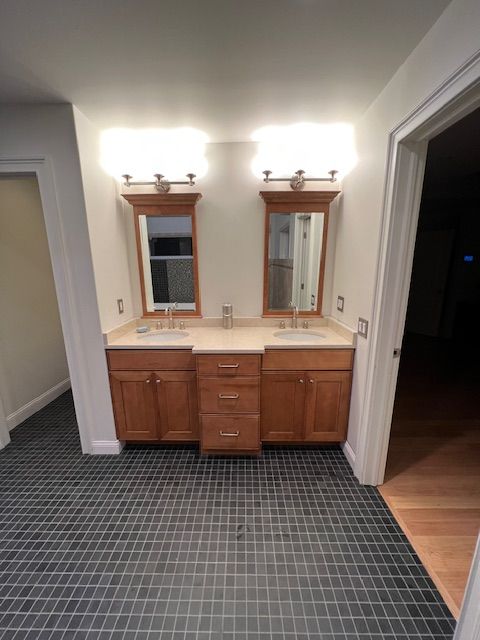A bathroom with two sinks and two mirrors.