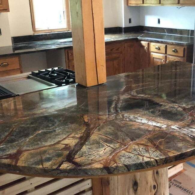 A kitchen with a marble counter top and wooden cabinets