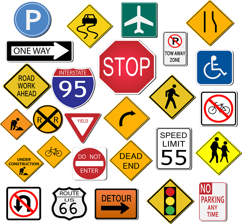 Assorted colorful road signs, including stop, speed limit, parking, detour, and warning signs, on a white background.