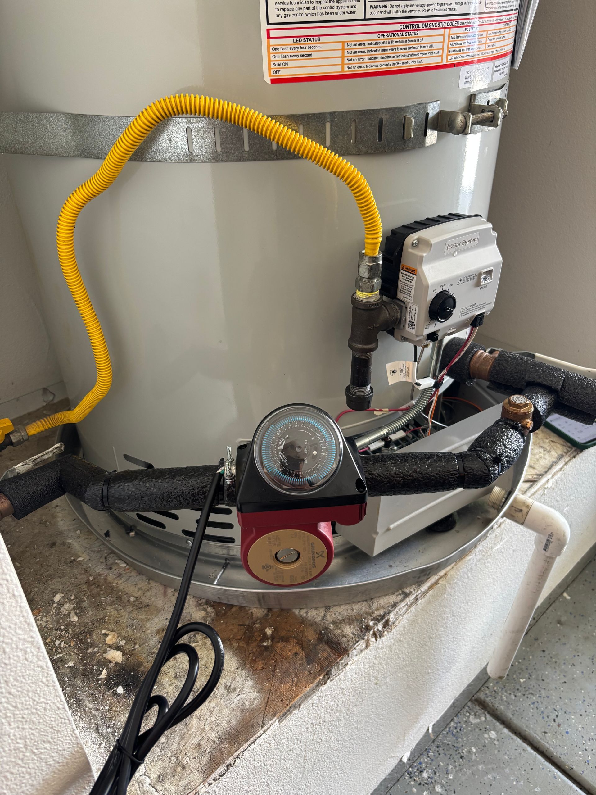 Air compressor with yellow hose and pressure gauge in a garage-like utility area