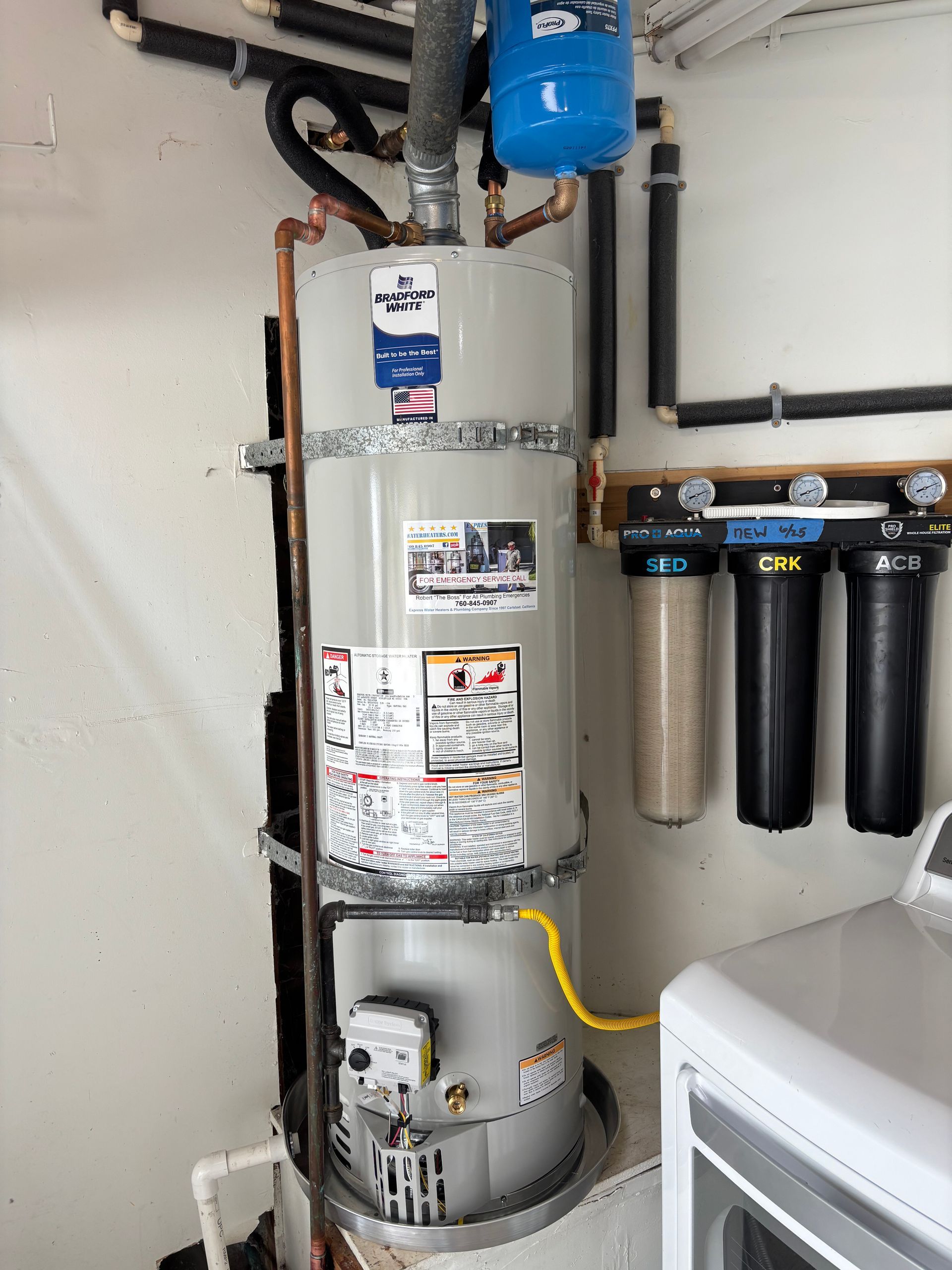 Water heater with pipes and attached filtration system in a utility room