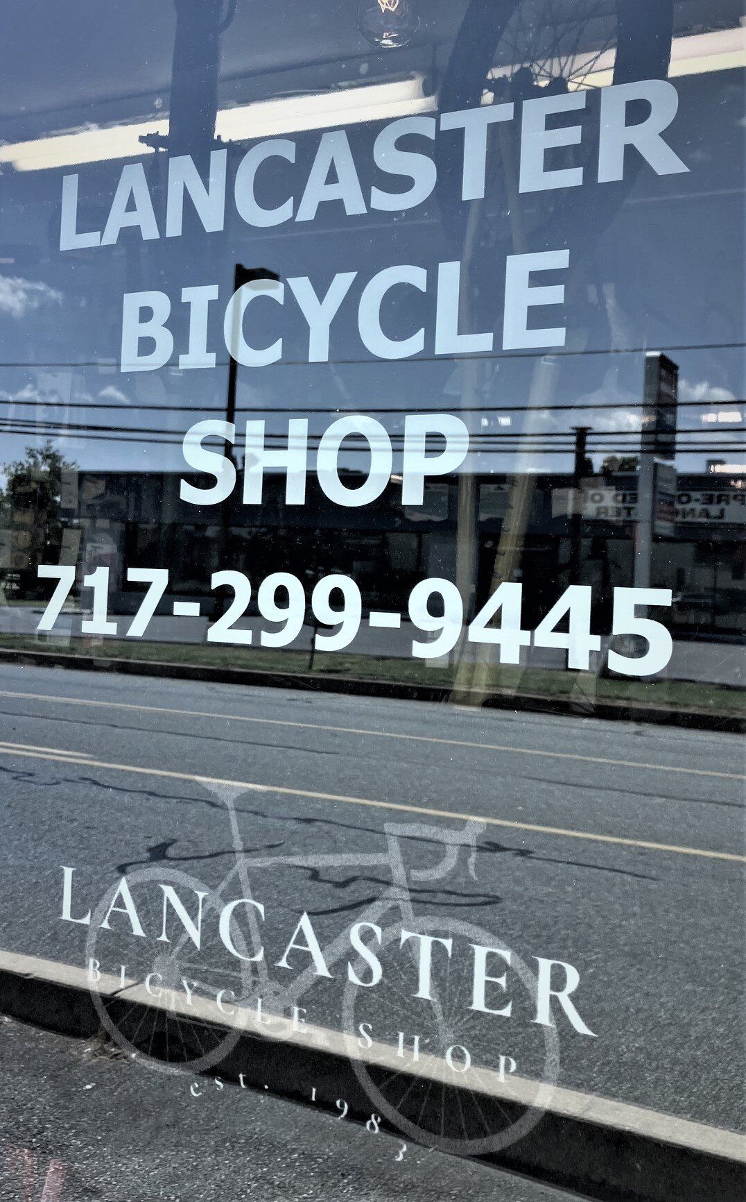 A sign for lancaster bicycle shop is on a window