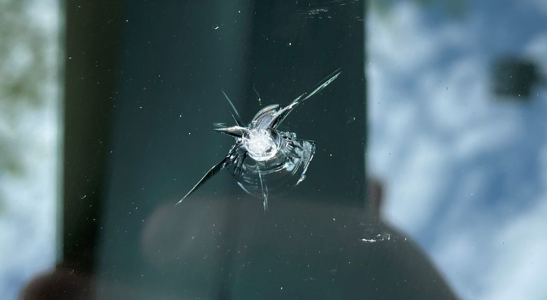 Before a windshield chip repair of a rock impact and small cracks in the glass.