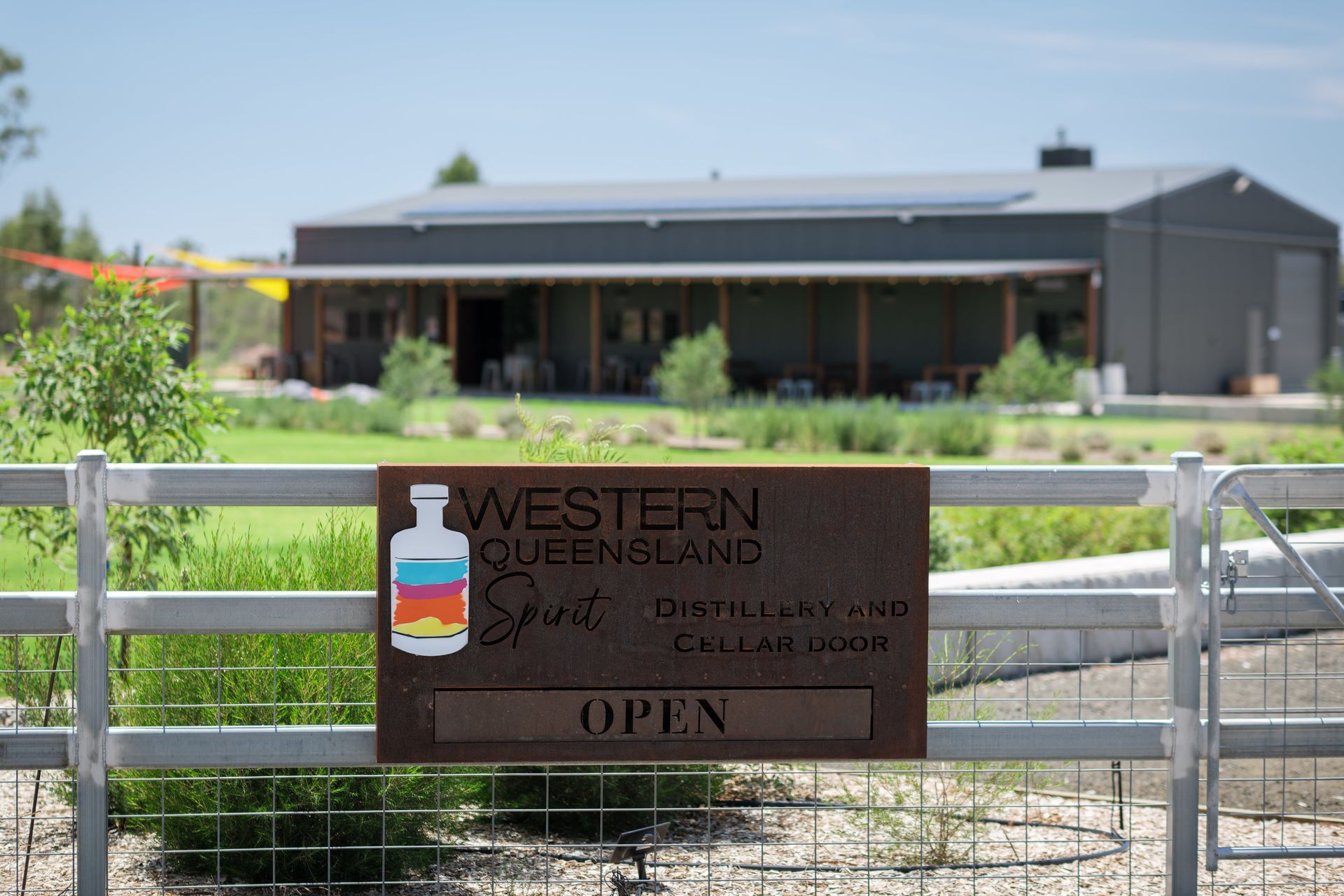 A sign on a fence says `` open '' in front of a building.