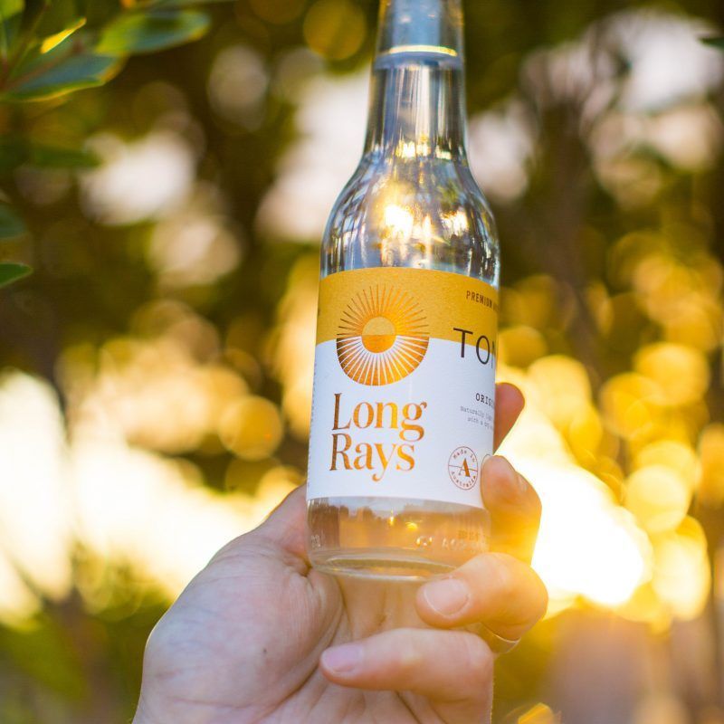 A person is holding a bottle of long rays
