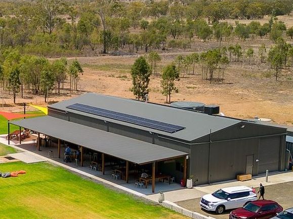 An aerial view of a large building with solar panels on the roof.