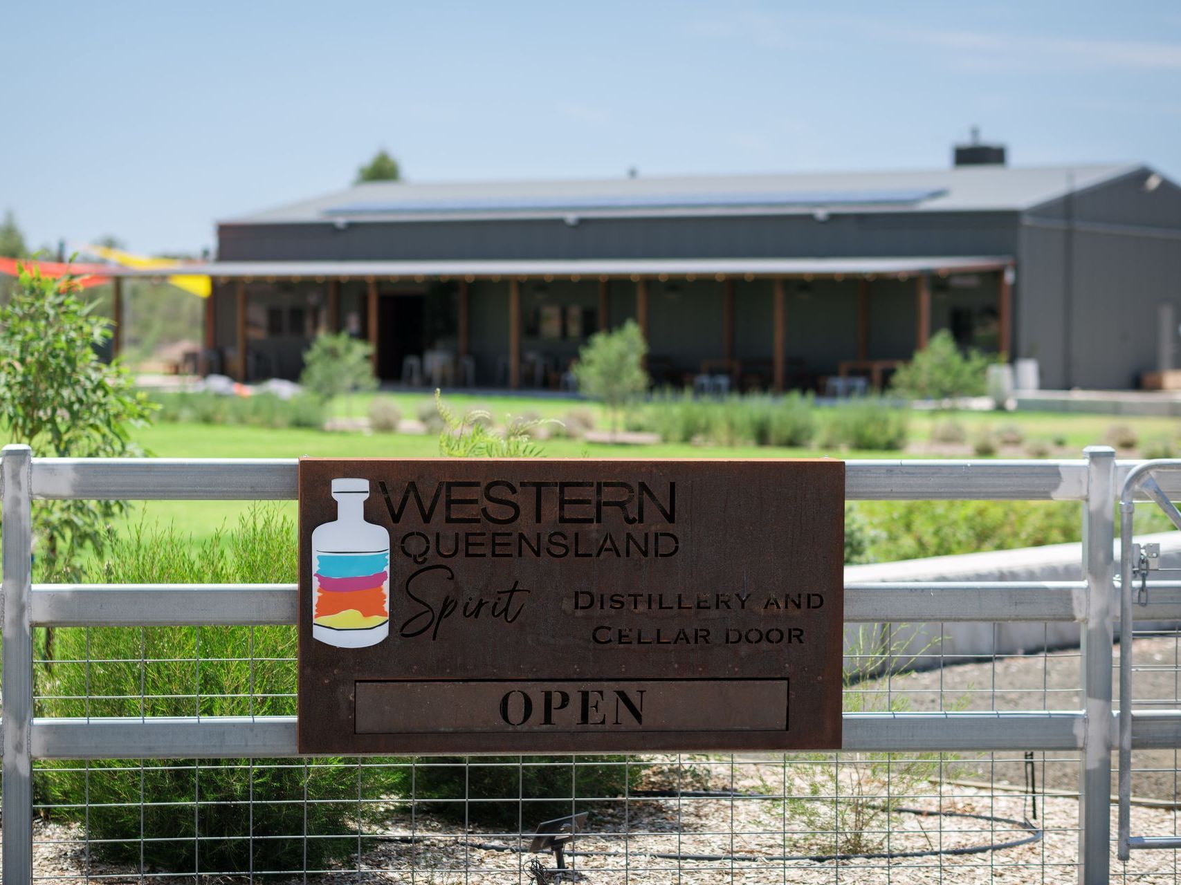 A sign on a fence in front of a building that says