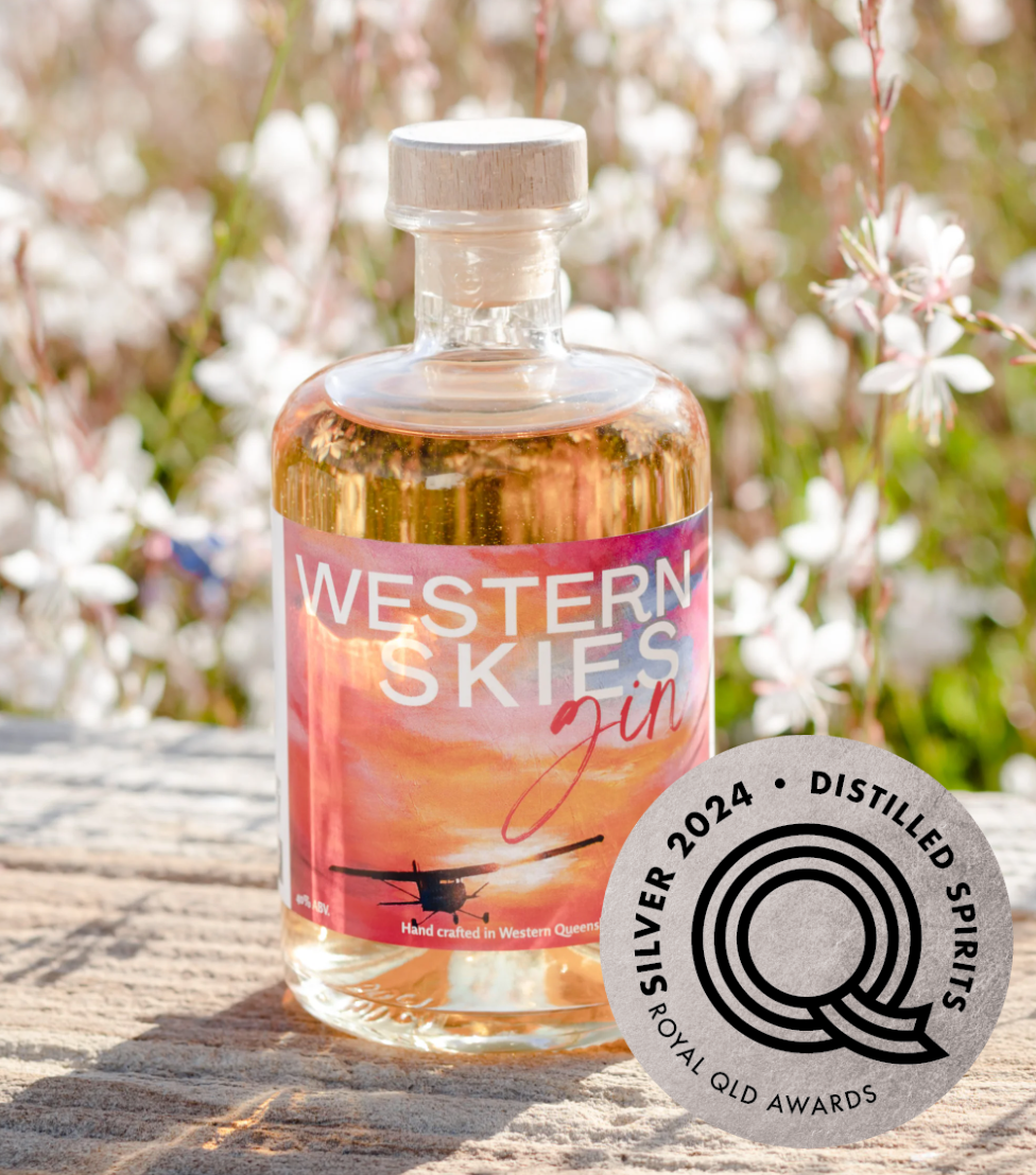 a bottle of western skies gin is sitting on a wooden table .