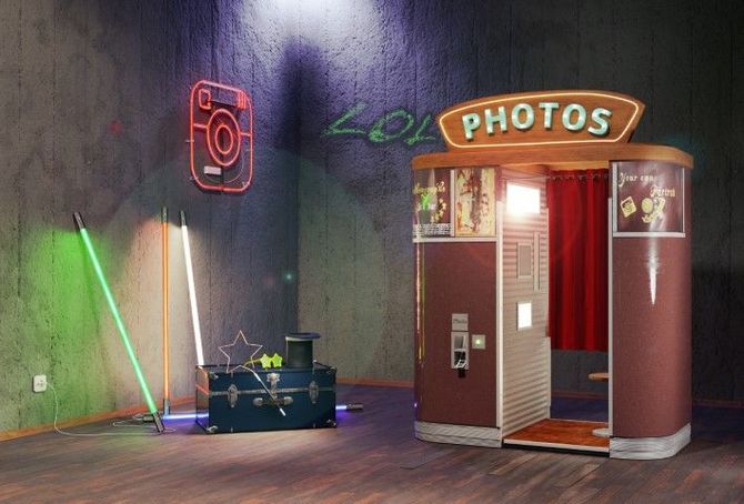 Neon-lit photo booth with red curtains and small DJ setup against a dark wall.