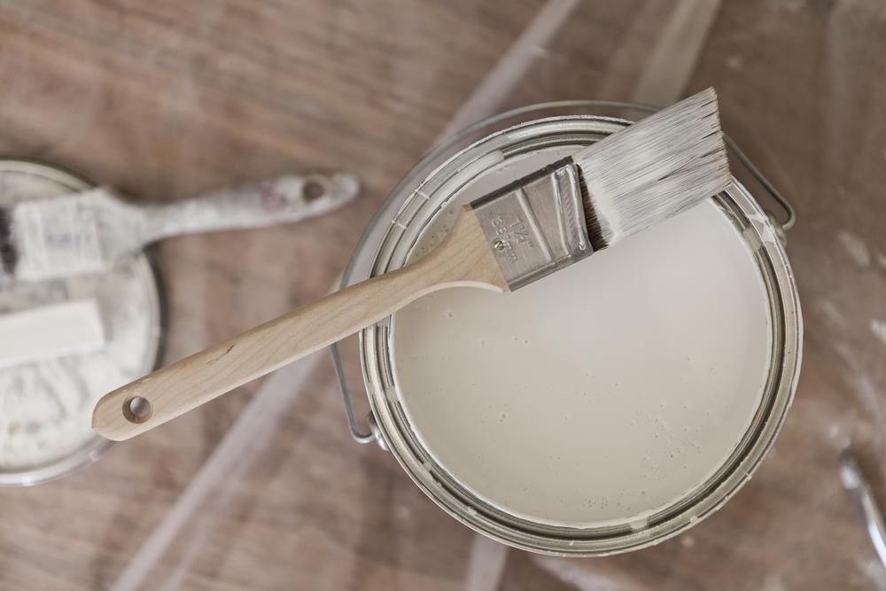 A Can Of White Paint With A Brush In It — Paint & Trade Supplies Lismore In Brunswick Heads, NSW