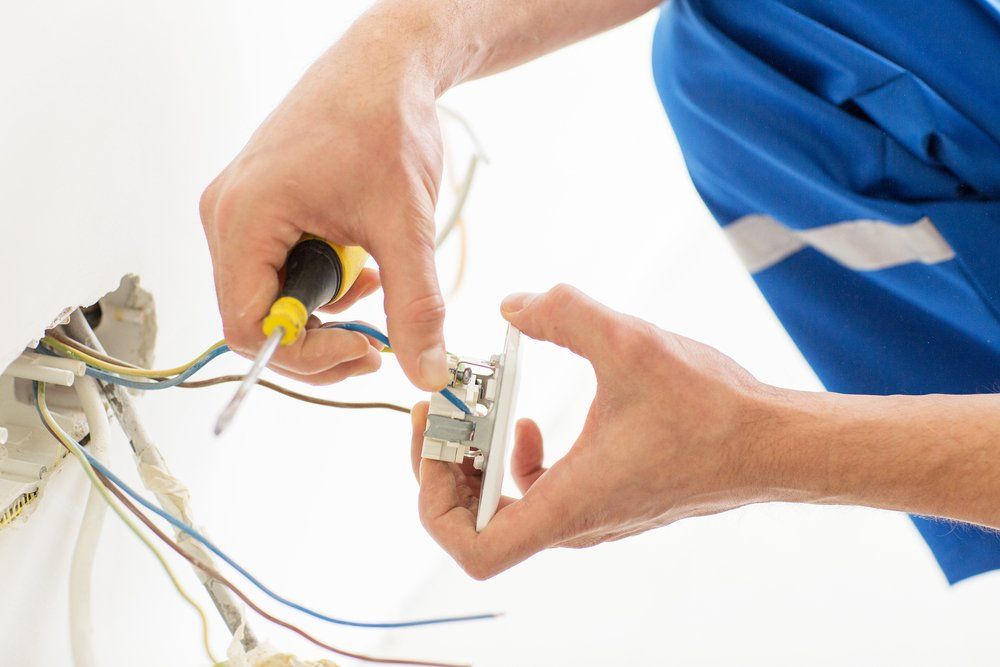 Close up of Electrician Hands with Screwdriver Fixing Socket — Hennig Electrical Services in Nambour, QLD