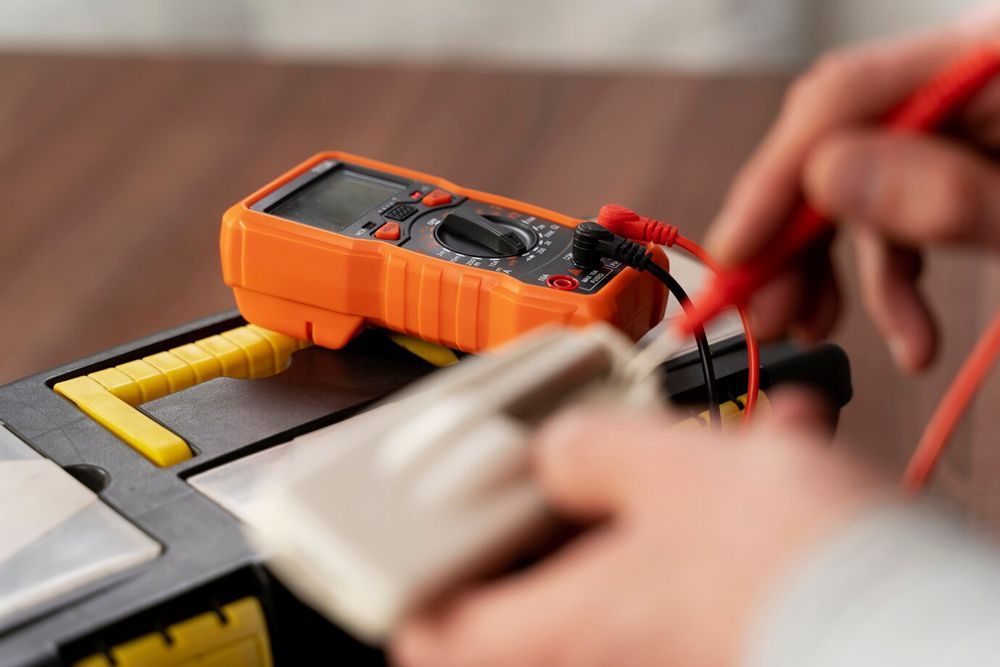A Close Up of a Person Using a Multimeter on a Toolbox — Hennig Electrical Services in Nambour, QLD