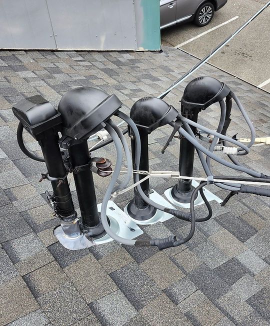 Portable charging stations with black and gray cables on a paved sidewalk near a building