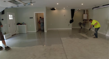 Workers smoothing reflective floor coating for epoxy flooring service in Parkville, MO