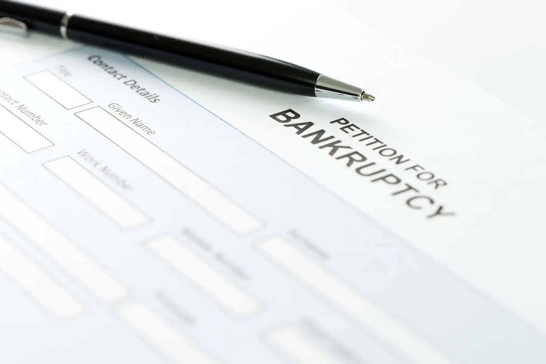 Pen and bankruptcy petition form on a white desk