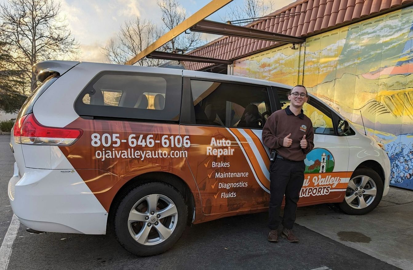 A man stands next to a white minivan | Ojai Valley Imports